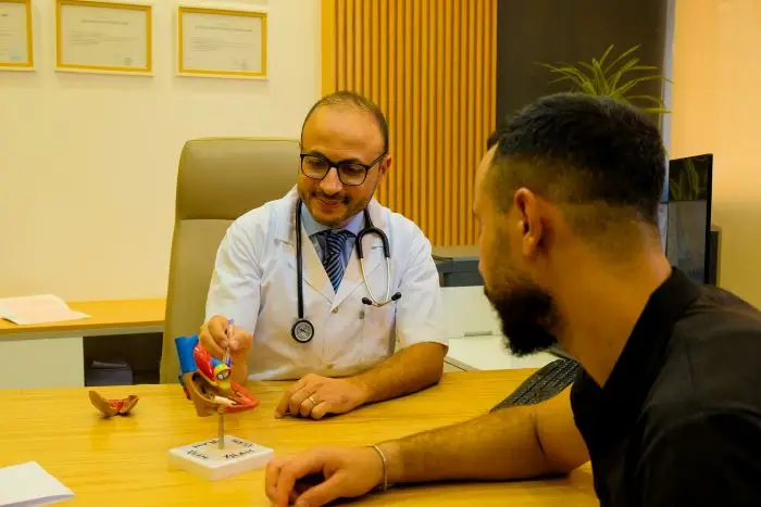 Dr EL ALAMI Youssef, cardiologue à Fès, expliquant un diagnostic à un patient lors d'une consultation